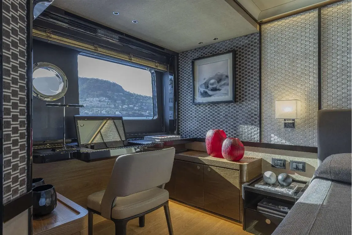 Modern office space features a desk, designer vases, a picture frame, and a scenic mountain view through large windows.